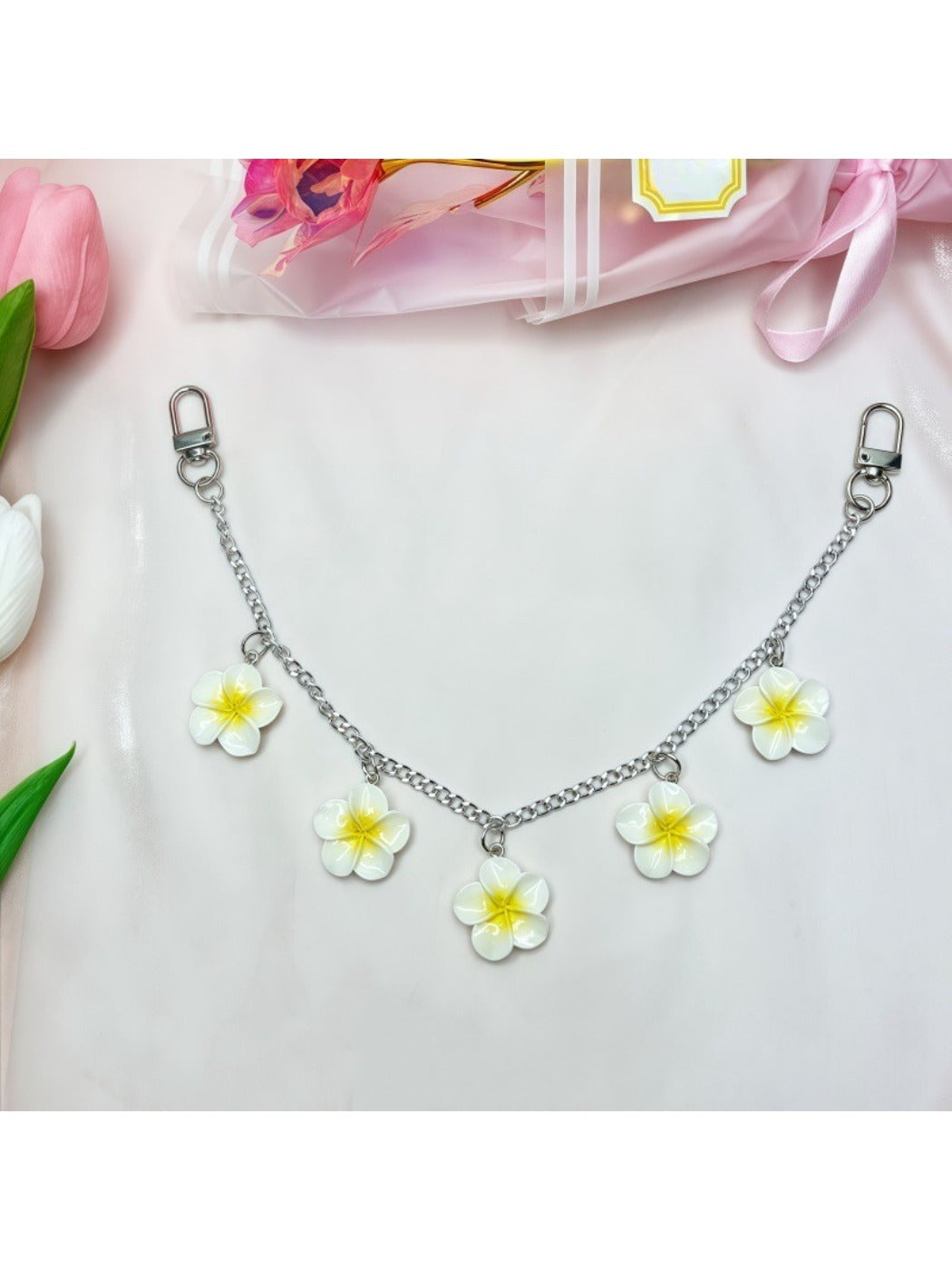 Minimalist flower pendant with polished gold surface on white background