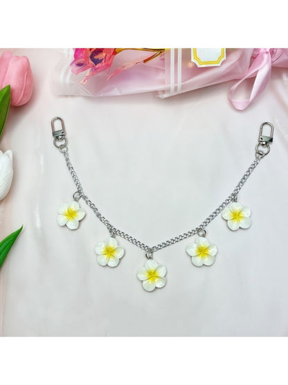 Minimalist flower pendant with polished gold surface on white background