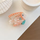 Beau colorful fish claw clip displayed alongside other hair accessories