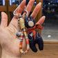 Hand holding vintage bear pendant keychain showing size and scale