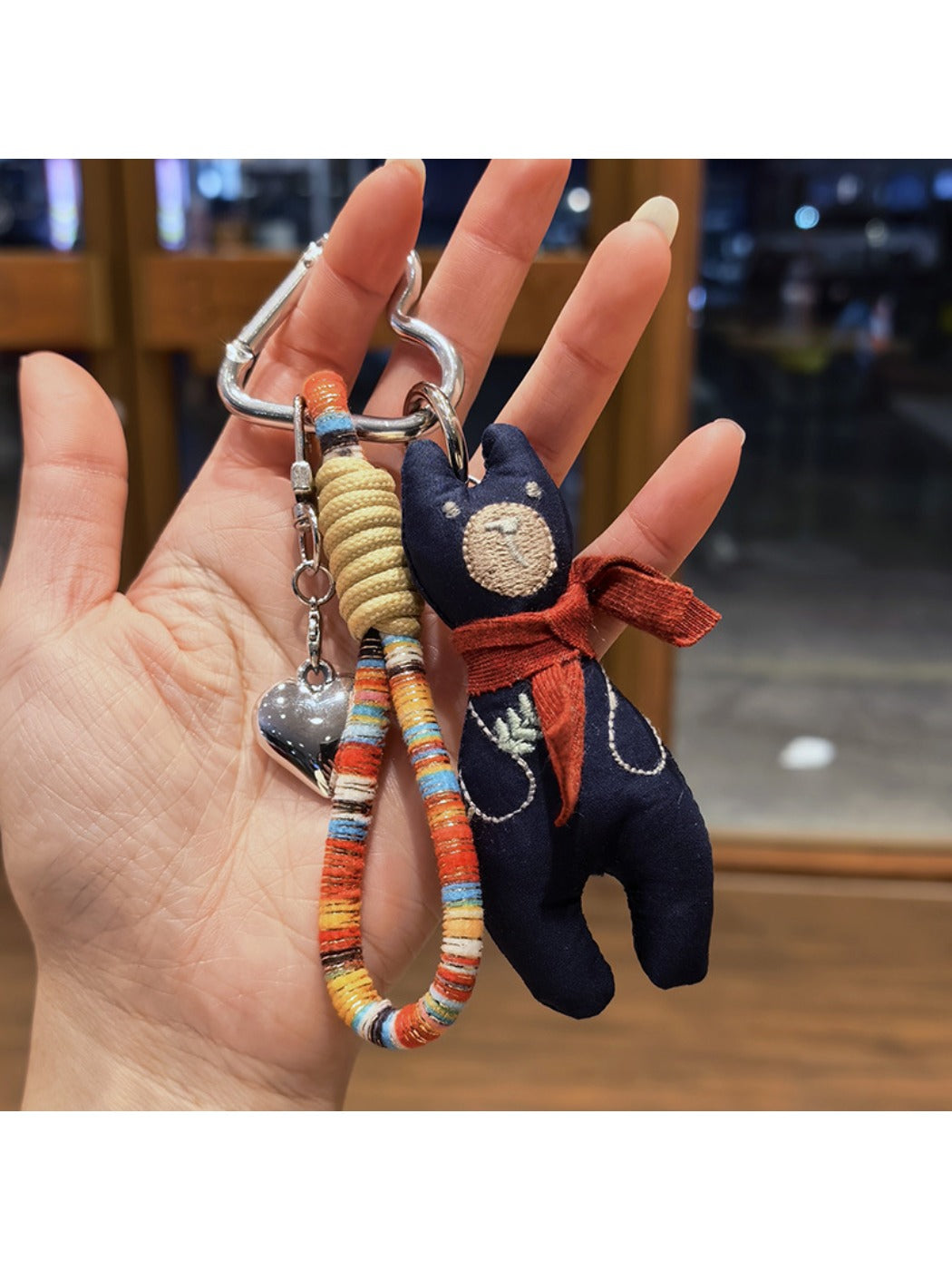 Hand holding vintage bear pendant keychain showing size and scale
