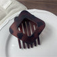 Beau openwork claw clip angled to show diamond shape and metal finish