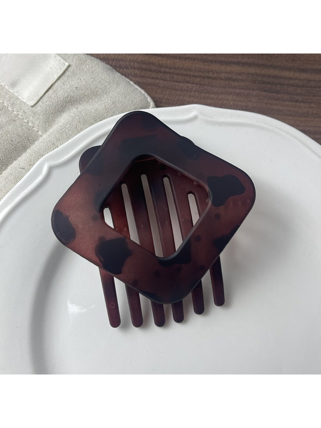 Beau openwork claw clip angled to show diamond shape and metal finish