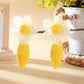 Close-up of earring hooks attached to raffia lace flower shapes