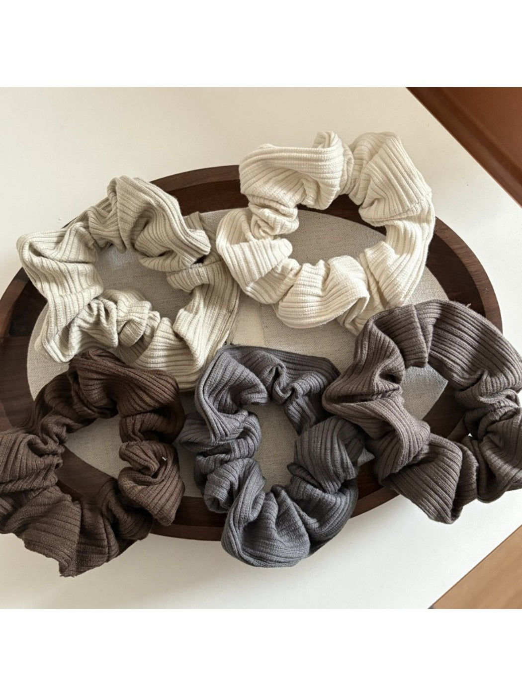 Close-up of Gifty striped scrunchie with simple white and beige stripes