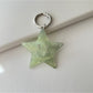 Silver five pointed star keychain hanging from a car ignition key