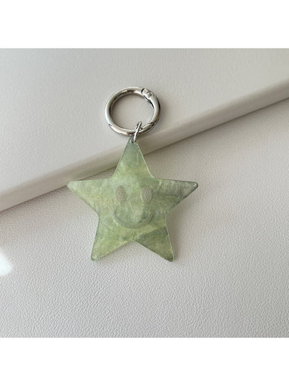Silver five pointed star keychain hanging from a car ignition key