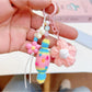 Crochet candy keychain attached to a set of keys on a wooden surface