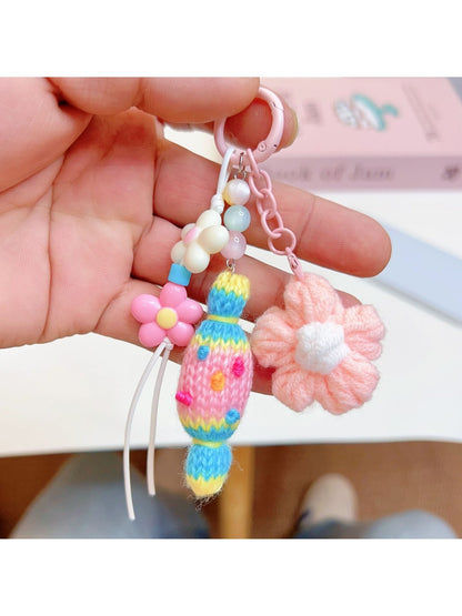 Crochet candy keychain attached to a set of keys on a wooden surface
