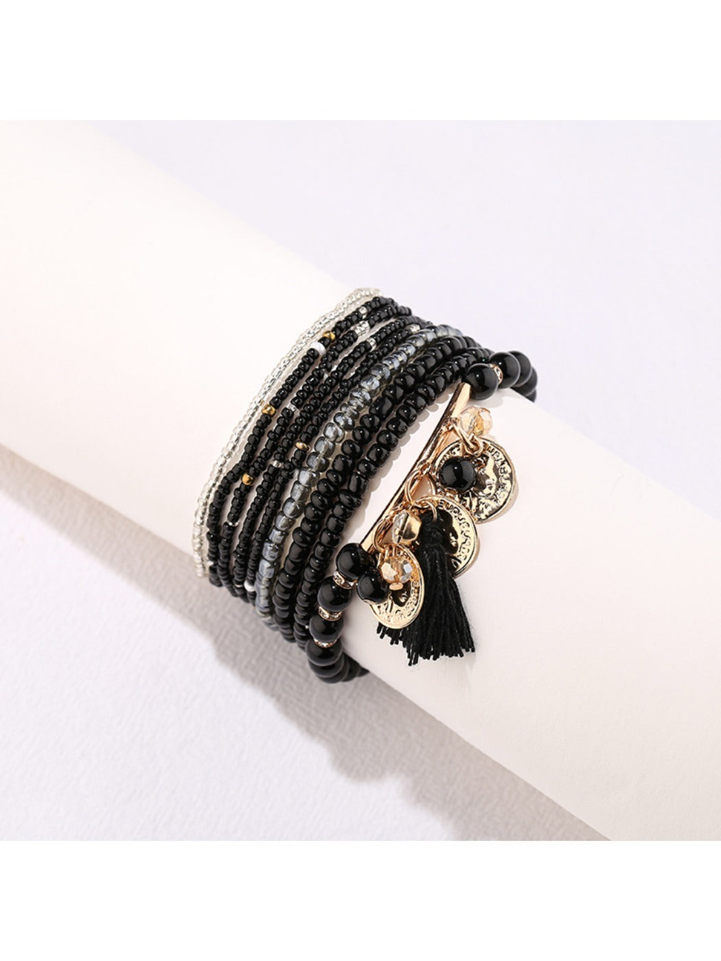 Side view of Lovra bracelet highlighting bead texture and metal tassel detail