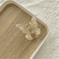 Beau butterfly claw clip displayed with other hair accessories on a flat surface