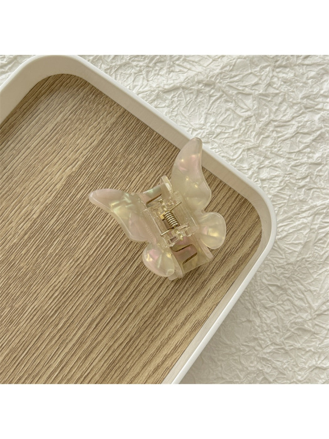 Beau butterfly claw clip displayed with other hair accessories on a flat surface