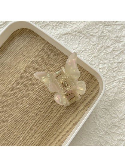 Beau butterfly claw clip displayed with other hair accessories on a flat surface