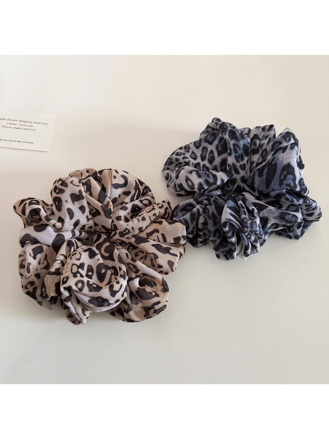 Leopard print scrunchie wrapped around a ponytail on a model