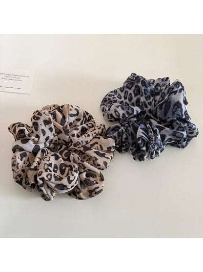 Leopard print scrunchie wrapped around a ponytail on a model
