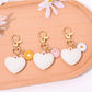 Red leather heart shaped keychain hanging from a gold keyring on a white surface