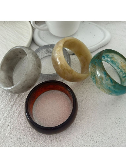 Close-up of Lovra round bangle bracelet showing smooth, shiny gold surface