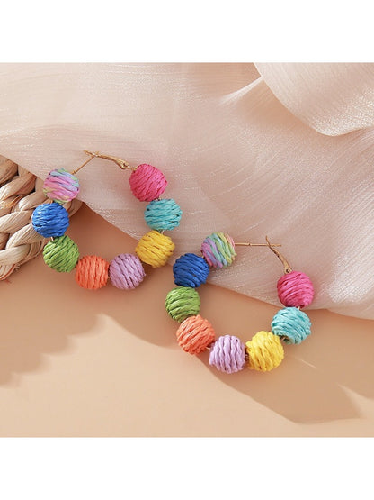 Side view of Earedge raffia round ball drop earrings showing woven texture