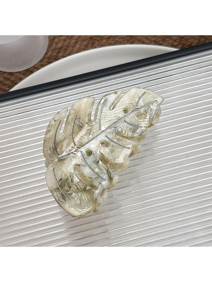 Beau delicate leaf shaped hair claw clip next to green leaves for aesthetic contrast