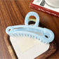 Beau hollow paperclip claw clip resting on a wooden surface