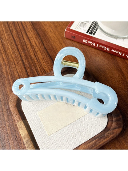 Beau hollow paperclip claw clip resting on a wooden surface