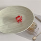 Beau small pastel pink flower claw clip resting on a wooden surface