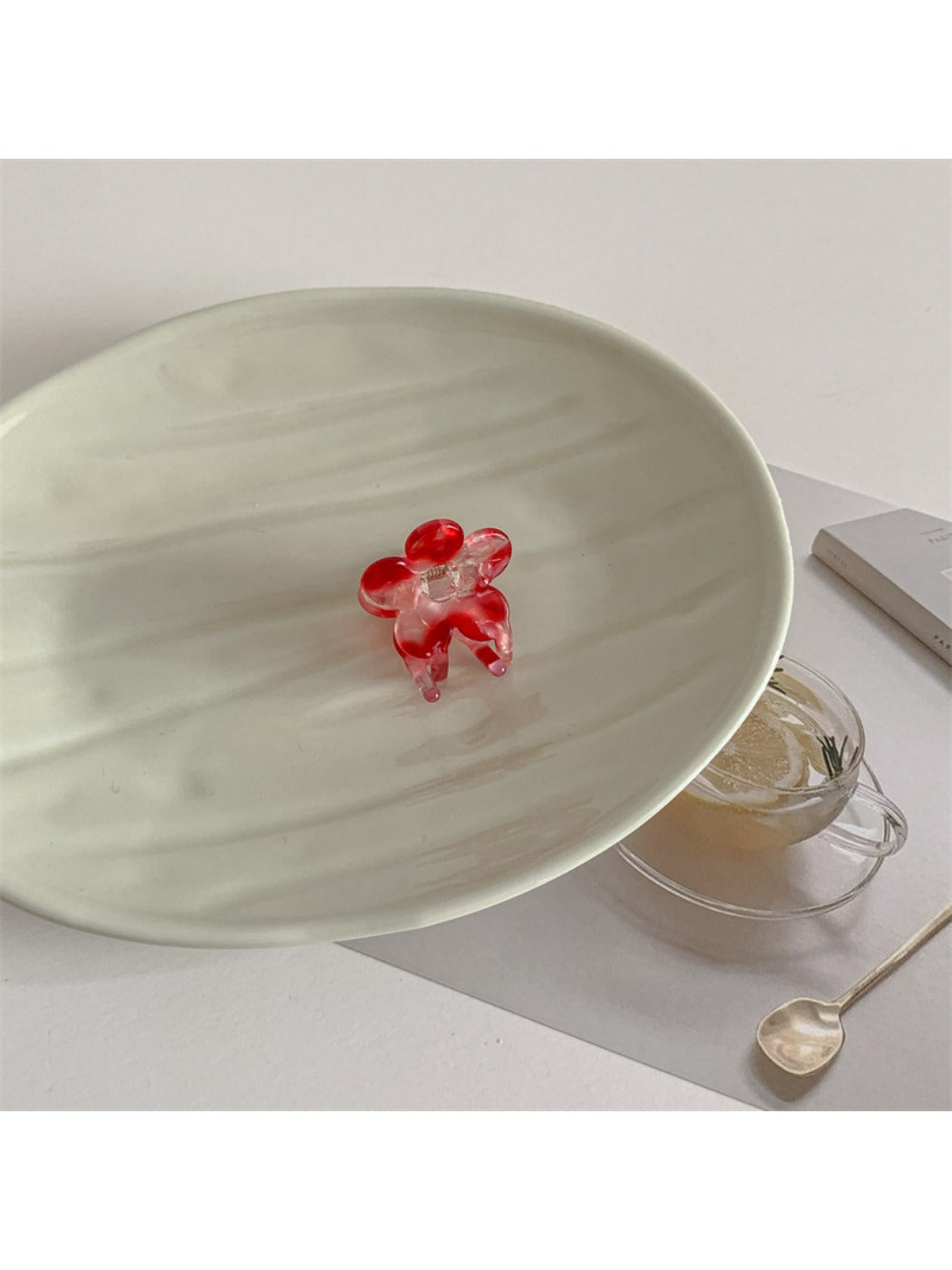 Beau small pastel pink flower claw clip resting on a wooden surface