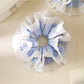 Close-up of blue striped fabric and ruffle details on scrunchie