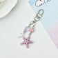 Starfish pendant keychain on a keyring with a blurred background