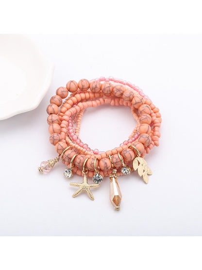 Lovra bracelet with ocean pendant and alternating blue and white beads close-up