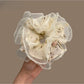 White tulle scrunchie with tiny pink and green floral pattern on a white background