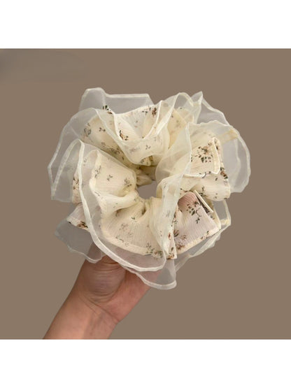 White tulle scrunchie with tiny pink and green floral pattern on a white background
