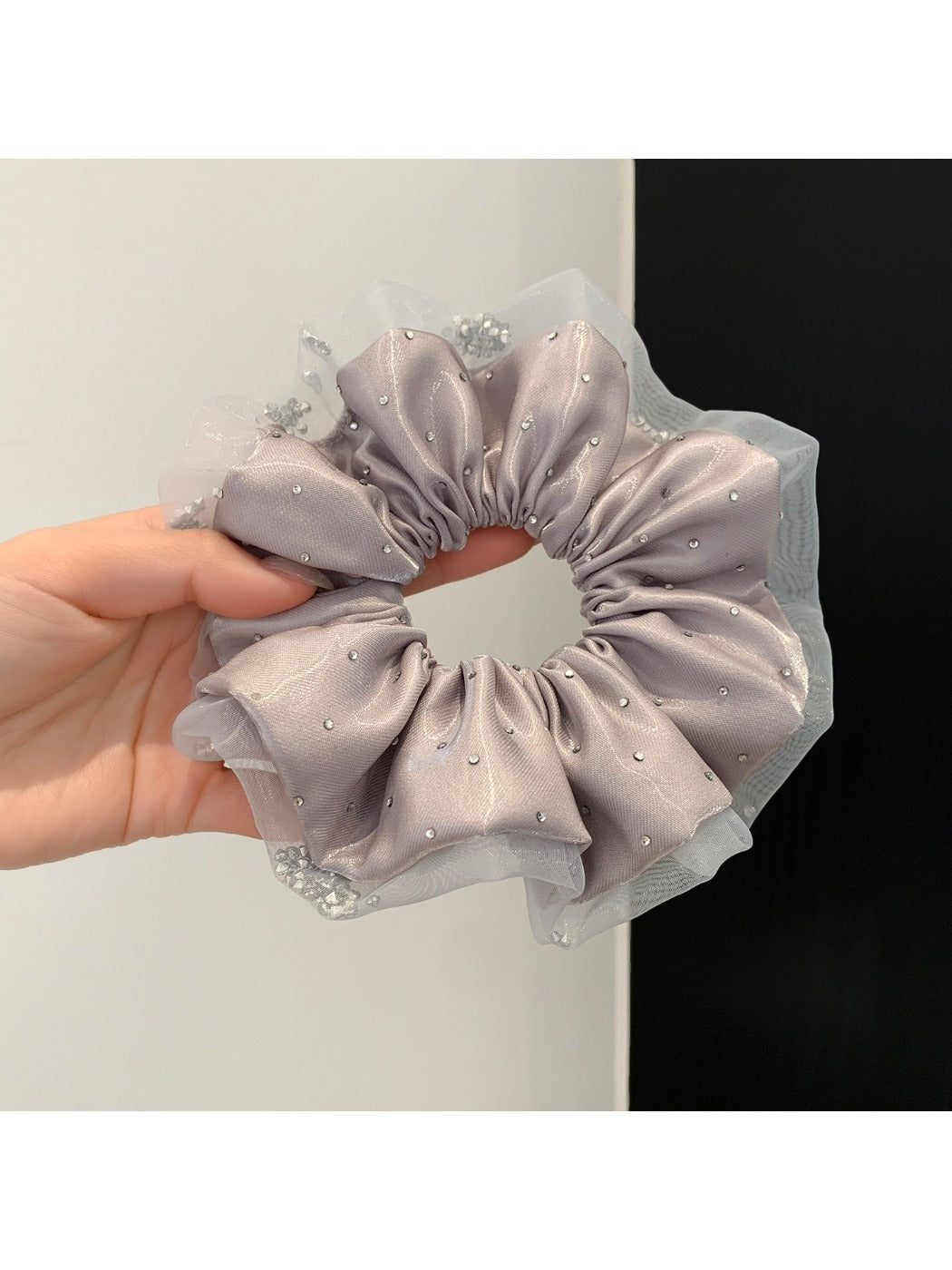 Pink satin scrunchie styled on a wrist as a bracelet accessory