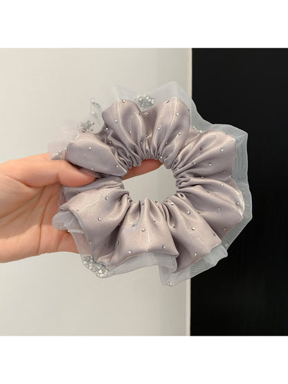 Pink satin scrunchie styled on a wrist as a bracelet accessory