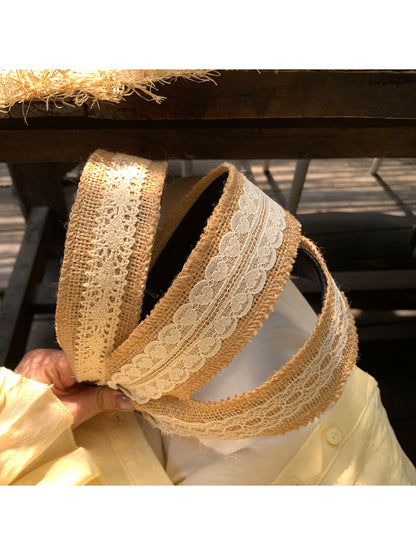 Close-up of woven lace detail on soft straw headband showing texture and pattern