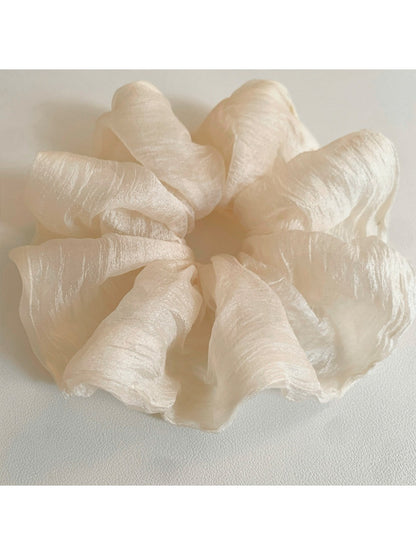 Thin solid color scrunchie wrapped around a ponytail on a model
