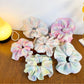 Multiple Gifty colorful ruffled scrunchies arranged in a circle on a flat surface