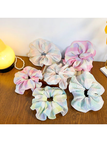 Multiple Gifty colorful ruffled scrunchies arranged in a circle on a flat surface