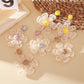 Close-up of Earedge elegant raffia flower shaped drop earrings on white background