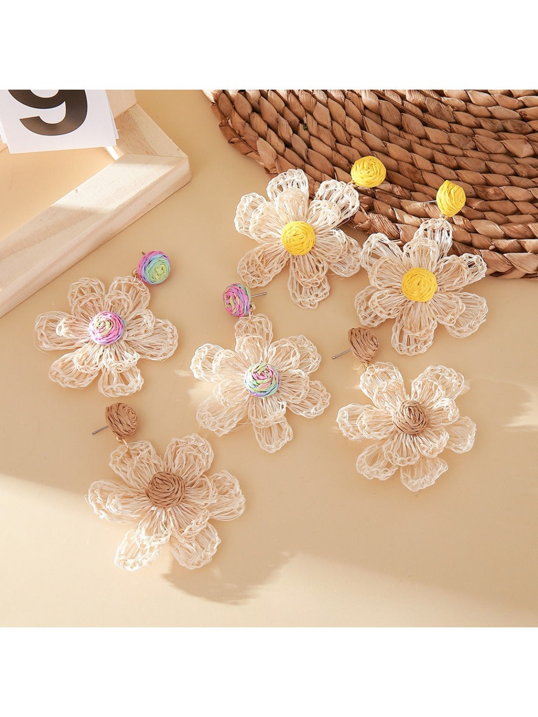 Close-up of Earedge elegant raffia flower shaped drop earrings on white background