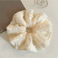 Ruffled scrunchie styled on a wrist as a fashion accessory