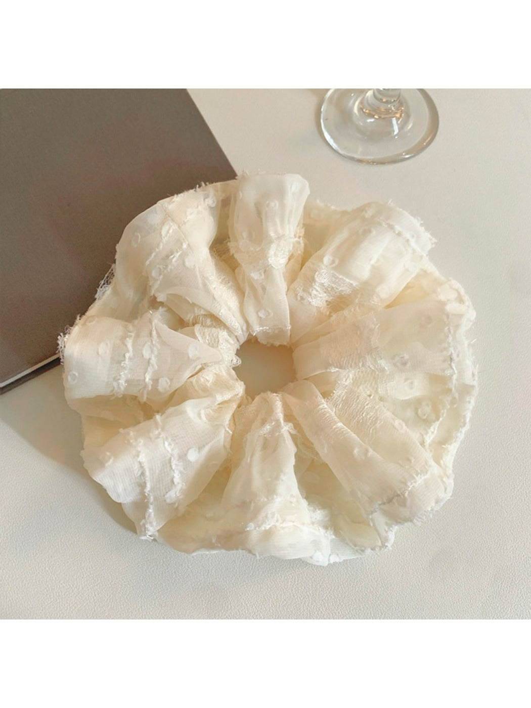 Ruffled scrunchie styled on a wrist as a fashion accessory