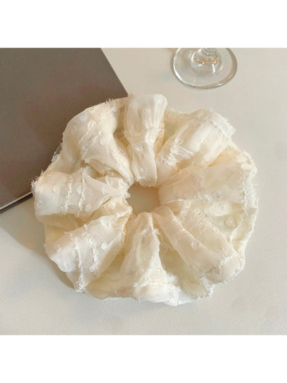 Ruffled scrunchie styled on a wrist as a fashion accessory