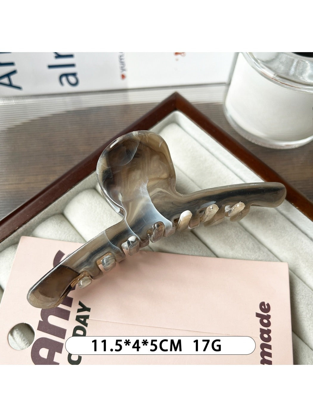 Beau minimalist large claw clip in matte black on a wooden surface