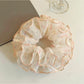 Close-up of Gifty chiffon scrunchie showing delicate floral pattern