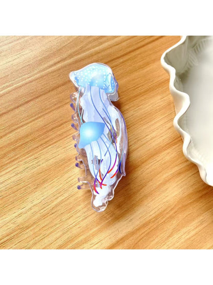 Beau jellyfish claw clip displayed with other colorful hair accessories on a wooden surface