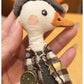 Duck charm keychain hanging from a bag zipper in natural light
