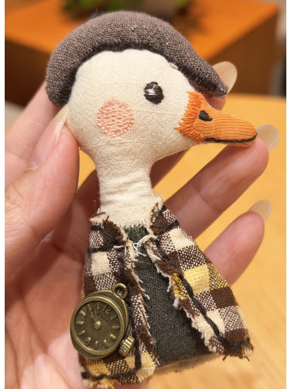 Duck charm keychain hanging from a bag zipper in natural light