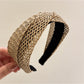 Gifty chic woven cross headband displayed flat with natural lighting