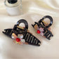 Beau crisscross flower claw clip open, displaying metal spring mechanism
